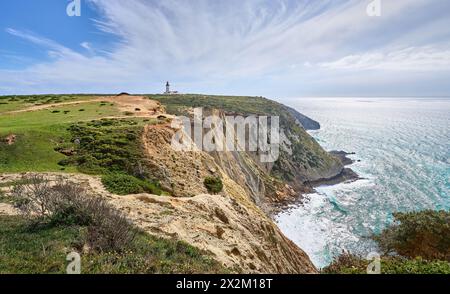 Nette aktive Frau, die mit ihrem E-Mountainbike auf den Klippen von Cabo Espichel in der Nähe von Sesimbra, Portugal, radelt Stockfoto