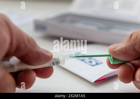 London. UK- 04.17.2024. Eine Person, die den Probenhalter öffnet, um eine Testprobe für einen Darmkrebstest zu entnehmen. Stockfoto