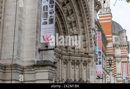 London. UK- 04.18.2024. Ein Seitenblick auf die Fassade des Victoria and Albert Museums mit Bannern, die die Sonderausstellungen zeigen. Stockfoto