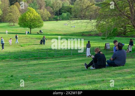 London. UK- 04.14.2023. Eine Menge von Menschen, die sich entspannen und einen Tag auf dem grünen Grasfeld eines Parks an einem schönen warmen, sonnigen Frühlingstag genießen. Stockfoto