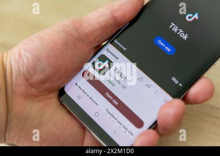 London. UK- 04.18.2024. Eine Hand, die ein Mobiltelefon hält und auf dem Bildschirm den TikTok-Namen und das Logo der Social-Media-Anwendung zur Videofreigabe anzeigt. Stockfoto