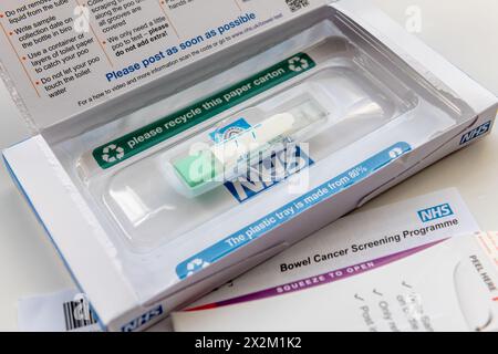 London. UK- 04.17.2024. Die offene Box und enthält ein NHS-Darmkrebs-Test-Kit, das per Post verschickt wird. Mit Probenhalter, Rücksendeumschlag und Let Stockfoto