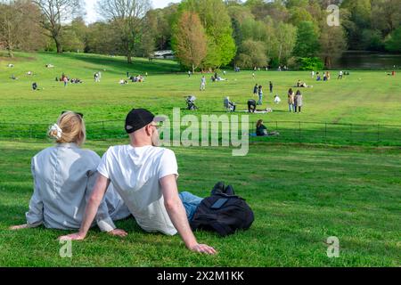London. UK- 04.14.2023. Eine Menge von Menschen, die sich entspannen und einen Tag auf dem grünen Grasfeld eines Parks an einem schönen warmen, sonnigen Frühlingstag genießen. Stockfoto