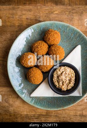 Blick von oben auf traditionelle niederländische Bitterballen mit Senf auf einem Teller auf einem Holztisch Stockfoto