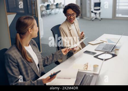 Zwei weibliche Experten für professionelle Führungskräfte diskutieren über die Zusammenarbeit mit Finanzbuchhaltungsunterlagen Stockfoto