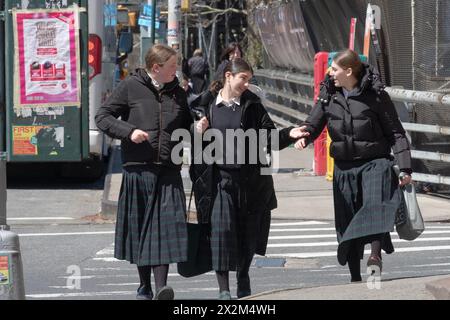 Klassenkameraden einer Pfarrschule für religiöse jüdische Mädchen gehen nach Hause, während sie ein animiertes Gespräch führen. An der Bedford Avenue in Williamsburg, NYC. Stockfoto