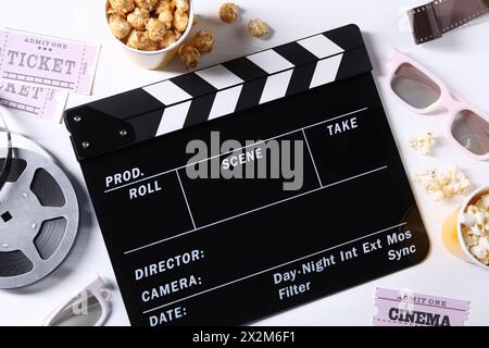 Flache Lay-Komposition mit Klapperbrett und Popcorn auf weißem Holztisch Stockfoto