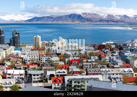 Reykjavik, Island, Landschaftsblick der Stadt mit farbenfrohen Wohngebäuden, Meerblick und schneebedeckten Berg Esjan. Stockfoto