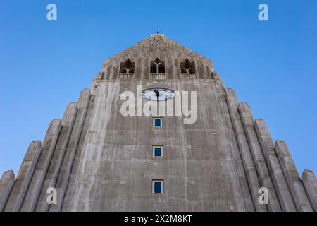 Hallgrimskirkja modernistische Kirche in Reykjavik, Island, flacher symmetrischer Blick auf den modernen Glockenturm aus Betonsäulen vor blauem Himmel. Stockfoto