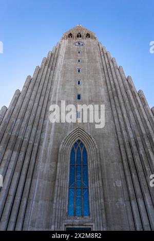 Hallgrimskirkja modernistische Kirche in Reykjavik, Island, flacher symmetrischer Blick auf den modernen Glockenturm aus Betonsäulen vor blauem Himmel. Stockfoto