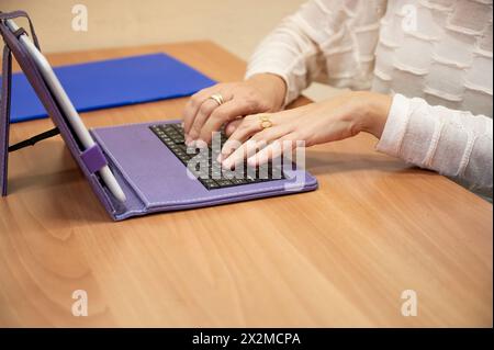 Detailaufnahme eines Profis, der mit einem Tablet mit Tastatur in einer Büroumgebung arbeitet Stockfoto