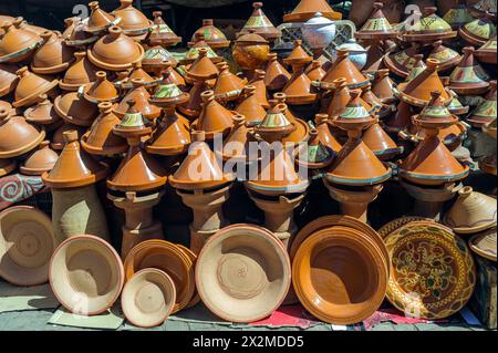 Eine lebendige Auswahl handgefertigter marokkanischer Tagine-Töpfe, stapelbar und bereit zum Verkauf auf einem Markt in Marokko, die die reiche kulinarische Kultur des Landes präsentieren Stockfoto