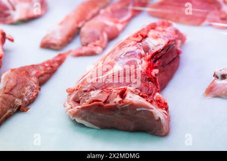 Verschiedene Stücke von rohem Kalbfleisch auf hellblauem Küchenpapier mit Texturen und Qualität für kulinarische Zubereitungen Stockfoto