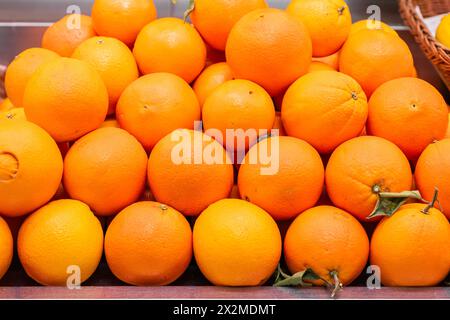 Eine lebendige Präsentation reifer Orangen, die ordentlich auf einem Marktstand angeordnet sind und ihren saftigen und frischen Reiz zum Ausdruck bringen Stockfoto