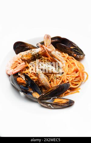 Köstliche Meeresfrüchte-Pasta mit saftigen Garnelen und frischen Muscheln, garniert mit einer duftenden Petersilie-Zubereitung auf einem Teller. Stockfoto