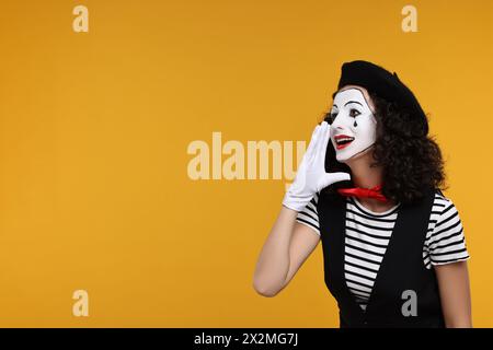 Lustige Mine mit Baskenmütze posiert auf orangem Hintergrund, Platz für Text Stockfoto