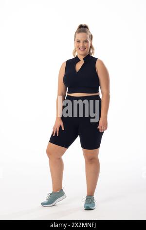 Weißes weibliches Model in Übergröße mit Händen auf der Hüfte auf weißem Hintergrund Stockfoto