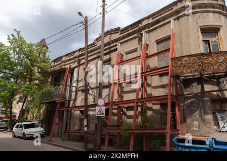 Tiflis, Georgien - 3. Mai 2019: Blick auf die alte Tiflis Straße mit alten kaputten Wohnhäusern und geparkten Autos. Georgischer Text: Ahospireli-Straße Stockfoto