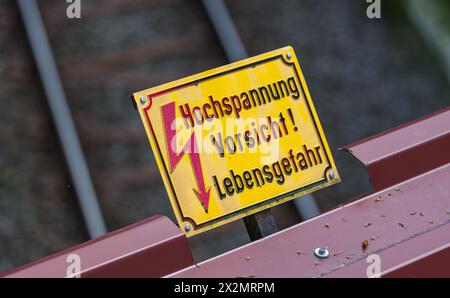 Ein Hinweisschild besagt, dass man vor Oberleitungen der Eisenbahn genügend Abstand halten soll. Elektrounfälle enden nicht selten tödlich. (Schluchse Stockfoto