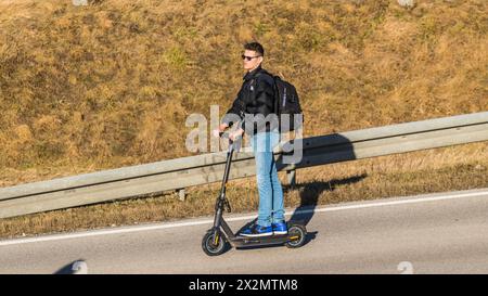 München, Deutschland - 1. Januar 2022: Ein junger Mann fährt auf einem Elektrotrottinet. Stockfoto