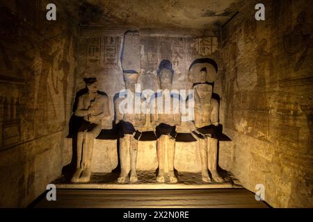 Abu Simbel, Ägypten - 28. November 2023: Inneres Heiligtum mit den Göttern Ra und Amun Re und Ramses II. Statuen im Abu Simbel Tempel in der Nähe von Assuan in Nubien Stockfoto