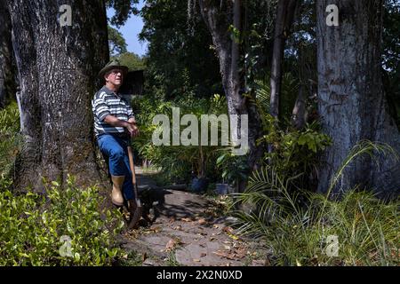 Ein älterer lateinamerikanischer Mann ruht von seiner Arbeit im Garten seines Hauses. Concept Gardening, Hobbys und Freizeit. Stockfoto