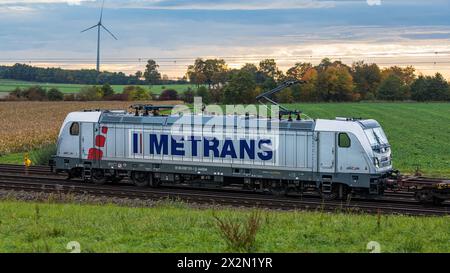 Eine Elektrolokomotive von Metrans vom Typ Bombardier Traxx AC3 zieht auf dem Bahnnetz der Deutschen Bahn einen Güterzug. (Hebertshausen, Deutschland, Stockfoto