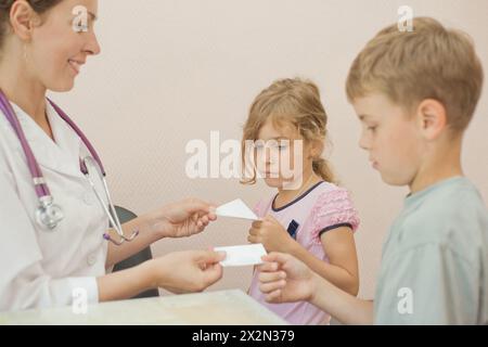 Doktor gibt Rezept für Bruder und Schwester, Fokus auf Mädchen Stockfoto