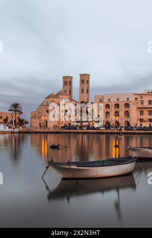 Blick auf den Hafen von Molfetta, dominiert von einem majestätischen Gebäude der lokalen Kathedrale Duomo vecchio di san Corrado. Stockfoto