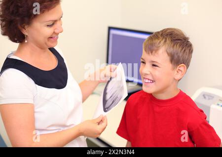 Zahnarzt hält Kieferröntgenbild für Happy Boy in der Zahnklinik Stockfoto