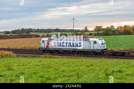 Eine Elektrolokomotive von Metrans vom Typ Bombardier Traxx AC3 zieht auf dem Bahnnetz der Deutschen Bahn einen Güterzug. (Hebertshausen, Deutschland, Stockfoto