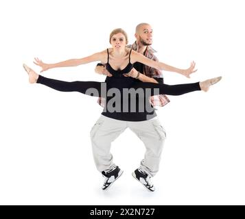 Breakdancer hält die Ballerina in Schwarz und steht auf Fußspitzen isoliert auf weißem Hintergrund. Die Frau streckte die Beine in Garn und spreizte ihre Arme zur Seite. Stockfoto