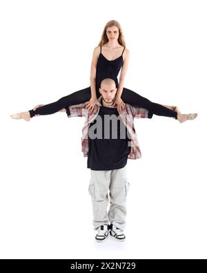 Breakdancer hält auf Schultern Ballerina in Schwarz isoliert auf weißem Hintergrund. Stockfoto