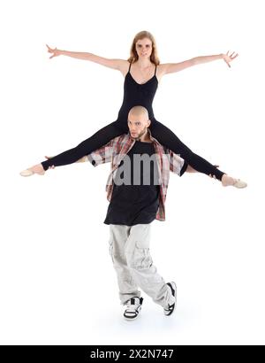 Breakdancer hält auf Schultern Ballerina und posiert isoliert auf weißem Hintergrund. Stockfoto