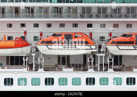 Orangefarbene Rettungsboote, die auf einem schönen weißen Passagierschiff montiert sind Stockfoto