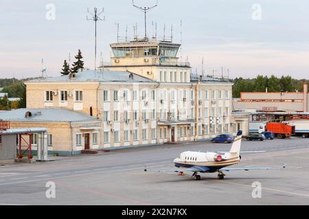 MOSKAU - 22. September: Ein kleines Linienflugzeug steht am 22. September 2011 in Moskau in der Nähe des Gebäudes mit Kontrollturm in Sheremetjewo. Bis 2015 hat Sheremetjewo seine Ziele erreicht Stockfoto