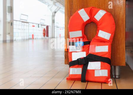 Die einzigartige orange Schwimmweste steht an Deck des Kreuzfahrtschiffes; Nahaufnahme Stockfoto