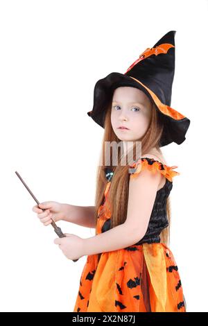 Mädchen in orangefarbenem Hexenkostüm für Halloween hält den Zauberstab isoliert auf weißem Hintergrund. Stockfoto