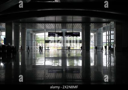 Silhouetten von Passagieren gehen auf einer Bahnhofshalle in Guangzhou, China Stockfoto