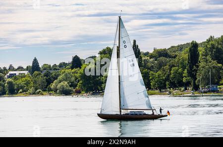 Ein Segelschiff fährt vor dem Ufer der Stadt Konstanz auf dem Bodensee. (Konstanz, Deutschland, 13.07.2022) Stockfoto