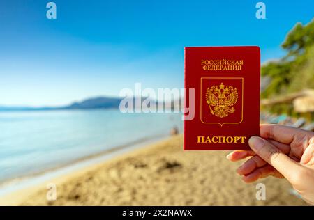 Mann mit russischem Pass vor dem Hintergrund eines tropischen Landes. Stockfoto