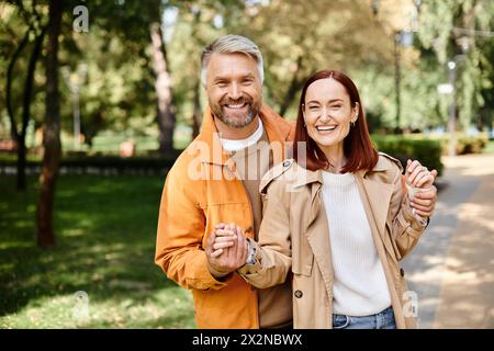 Ein Paar, lässig gekleidet, schlendert durch einen ruhigen Park. Stockfoto