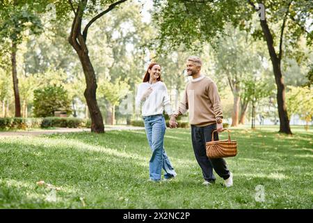 Ein Paar, das Hände hält und gemütlich durch einen Park läuft. Stockfoto