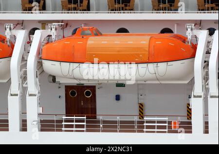 Orangefarbenes Rettungsboot auf dem großen weißen Passagierdeck montiert Stockfoto