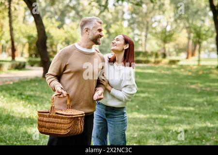 Ein Paar, lässig gekleidet, spaziert gemütlich durch einen Park, umgeben von Grün. Stockfoto