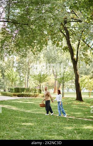 Ein liebevolles Paar, lässig gekleidet, spaziert durch einen friedlichen Park. Stockfoto