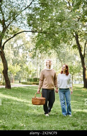 Ein Paar, lässig gekleidet, friedlich durch einen Park spazieren. Stockfoto