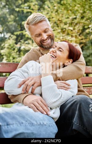 Mann und Frau sitzen friedlich zusammen auf einer ruhigen Bank im Park. Stockfoto