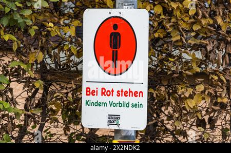 Ein Schild der Verkehrswacht besagt, dass auch erwachsene Personen bei roter Ampel stehen bleiben sollen und so ein Vorbild für Kinder sein sollen. (K Stockfoto