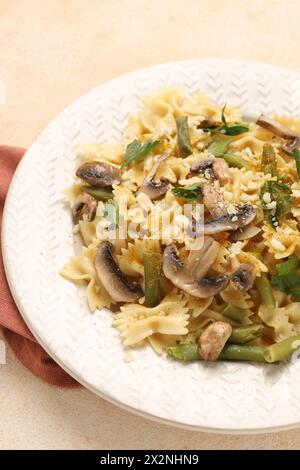 Vegetarische Pasta mit Pilzen, Petersilie, Bohnen und Käse auf orangefarbenen Tischen, Nahaufnahme Stockfoto